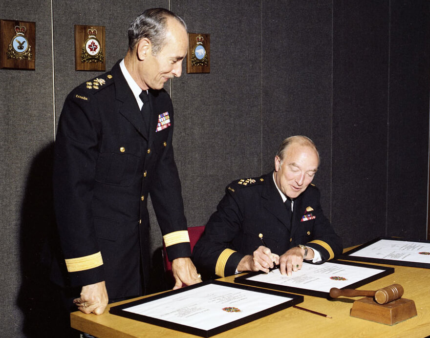 Signature des parchemins lors de la passation de commandement du Chef d’état-major de la Défense entre le général Dextraze et l’amiral Falls, 31 août 1977